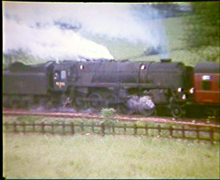 This is taken from an 8mm cine film frame and shows 92230 banking the rear of the WRS special ascending the Lickey Bank on 14th June 1964.